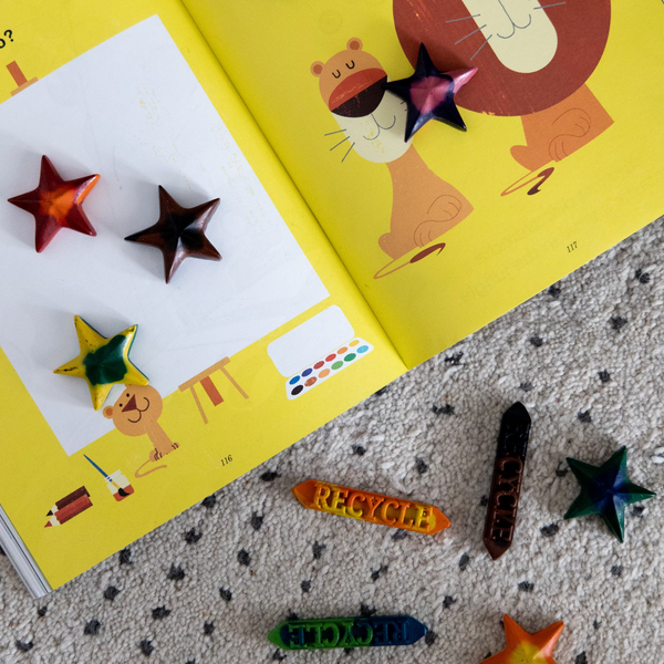 Recycled eco-friendly swirl crayons and sticks in a coloring book.