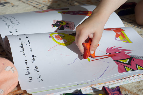 A child coloring with the star shaped eco-friendly recycled crayon in a coloring book.